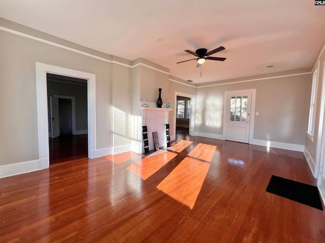 unfurnished living room featuring ceiling fan, dark hardwood / wood-style floors, and ornamental molding