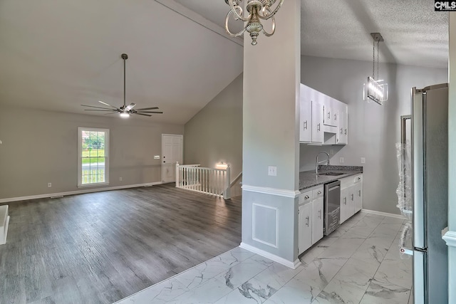 kitchen with sink, white cabinetry, vaulted ceiling, and stainless steel appliances