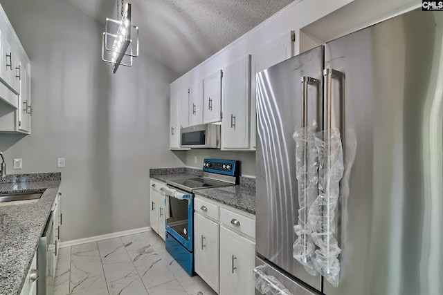 kitchen with white cabinetry, sink, appliances with stainless steel finishes, a textured ceiling, and hanging light fixtures