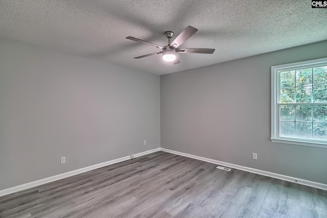 spare room with wood-type flooring, ceiling fan, and a textured ceiling