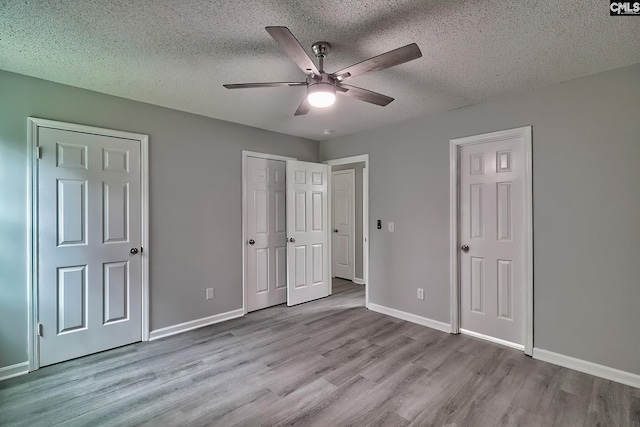 unfurnished bedroom featuring light hardwood / wood-style floors, ceiling fan, and a textured ceiling