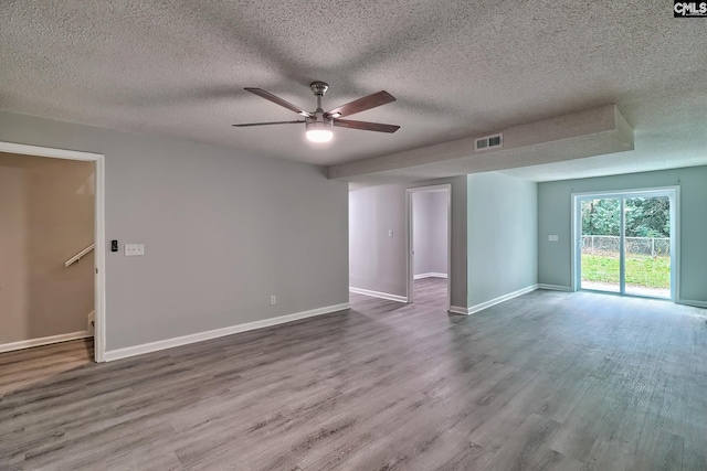 empty room with hardwood / wood-style flooring, ceiling fan, and a textured ceiling