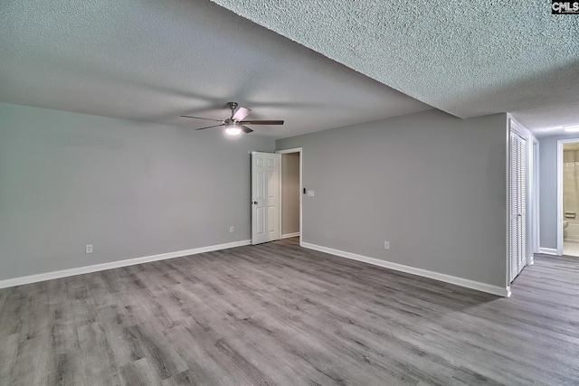 empty room with light hardwood / wood-style floors, ceiling fan, and a textured ceiling