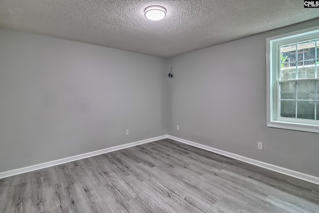 empty room featuring a textured ceiling and light hardwood / wood-style floors