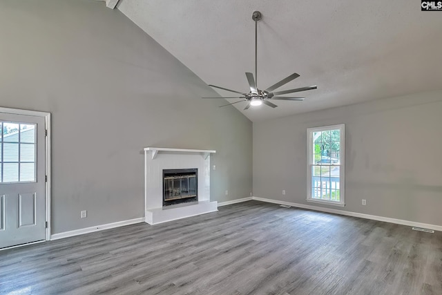 unfurnished living room featuring high vaulted ceiling, light hardwood / wood-style floors, and a healthy amount of sunlight