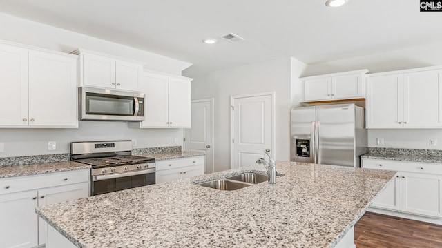 kitchen with white cabinets, sink, light stone countertops, and stainless steel appliances