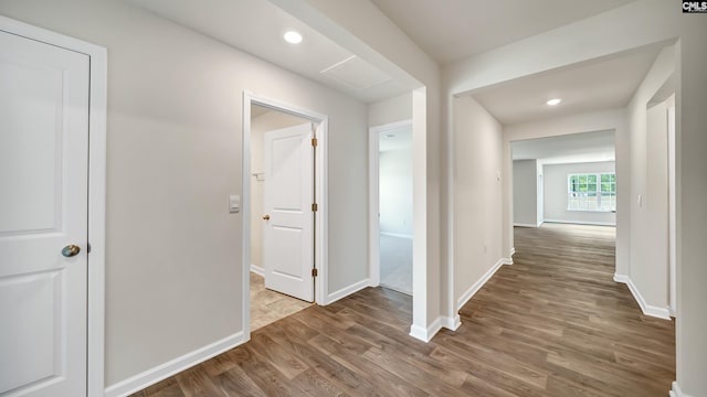 corridor with hardwood / wood-style flooring