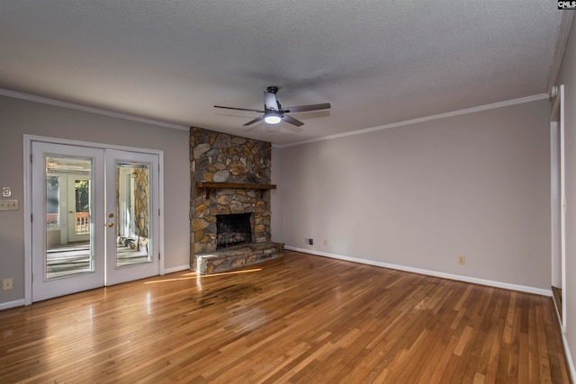 unfurnished living room with french doors, a fireplace, a textured ceiling, hardwood / wood-style flooring, and ceiling fan