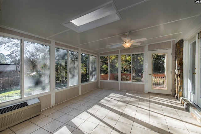 unfurnished sunroom featuring lofted ceiling with skylight, a wall mounted AC, ceiling fan, and plenty of natural light