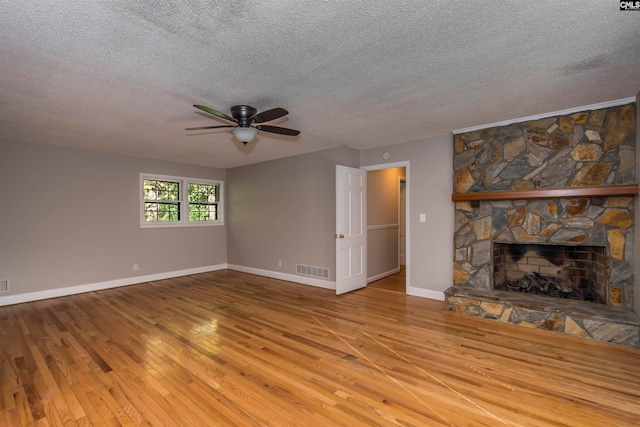 unfurnished living room with a fireplace, wood-type flooring, and a textured ceiling