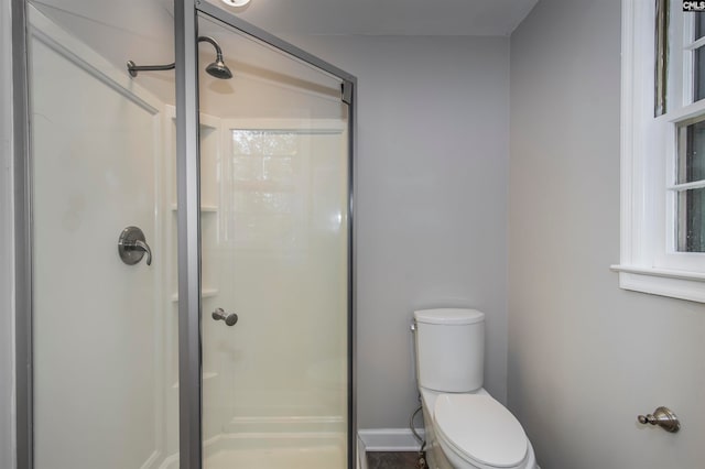 bathroom featuring walk in shower and toilet