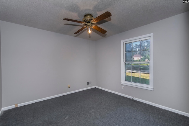 unfurnished room featuring a textured ceiling, ceiling fan, and dark carpet