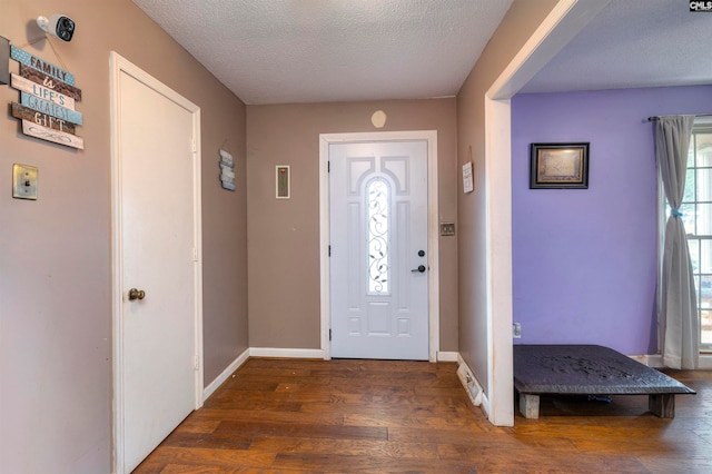 foyer featuring dark hardwood / wood-style flooring and a textured ceiling