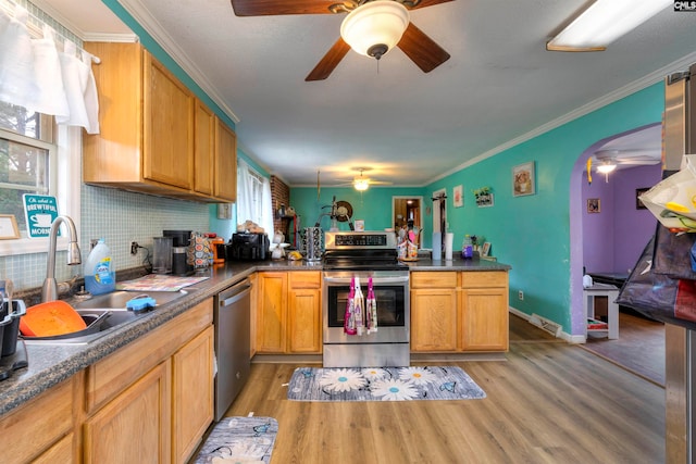 kitchen with crown molding, stainless steel appliances, decorative backsplash, sink, and light hardwood / wood-style flooring