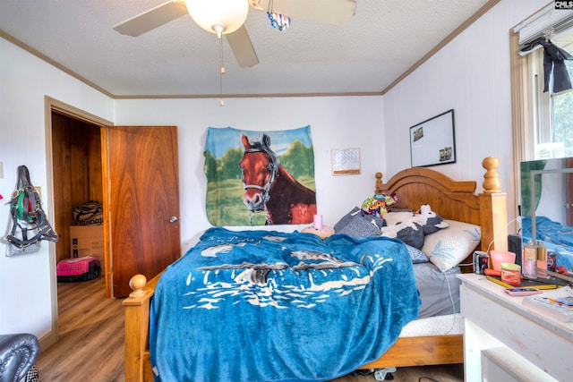 bedroom featuring ornamental molding, a textured ceiling, hardwood / wood-style flooring, and ceiling fan