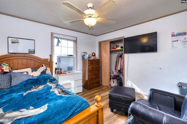 bedroom featuring a closet, ceiling fan, a textured ceiling, and light hardwood / wood-style floors