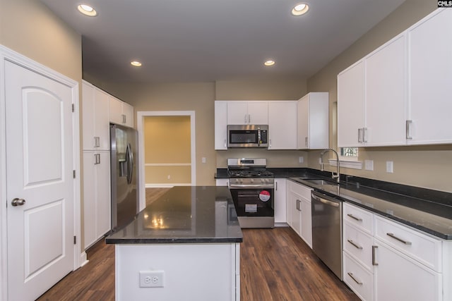 kitchen featuring a center island, sink, dark wood-type flooring, appliances with stainless steel finishes, and white cabinets