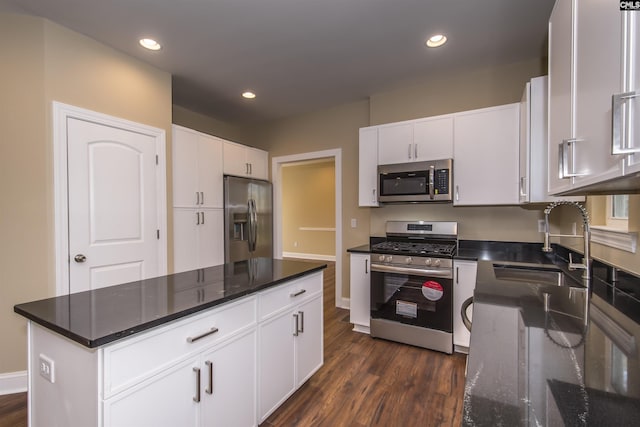 kitchen featuring appliances with stainless steel finishes, sink, dark hardwood / wood-style flooring, and white cabinetry