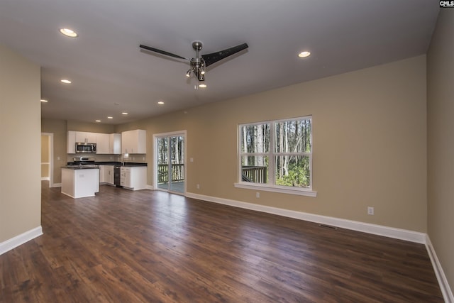 unfurnished living room with ceiling fan and dark hardwood / wood-style floors