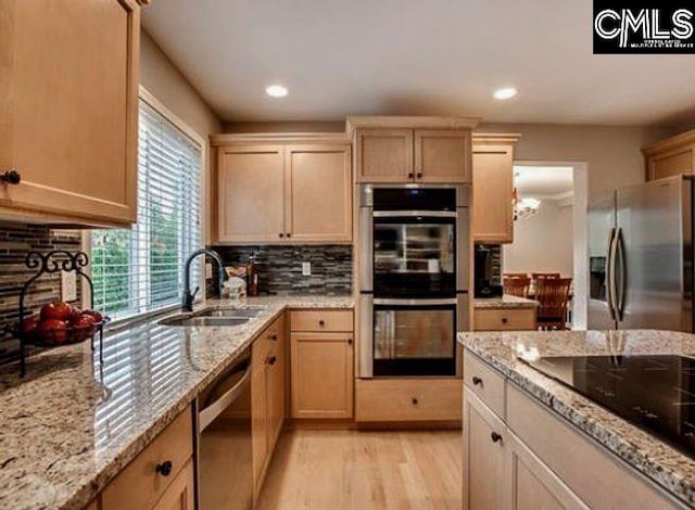 kitchen with tasteful backsplash, appliances with stainless steel finishes, sink, and light brown cabinets