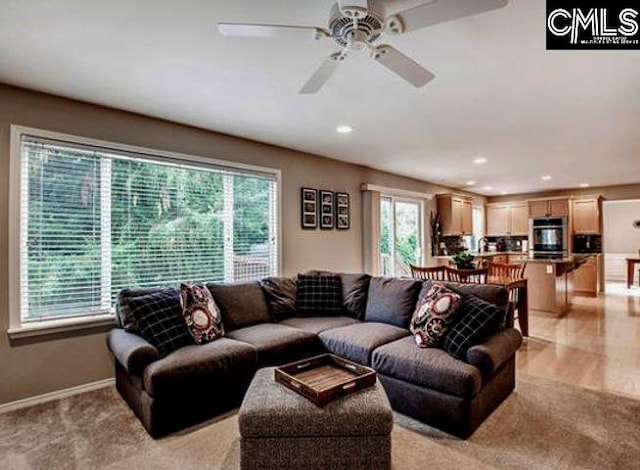 carpeted living room featuring ceiling fan and a wealth of natural light