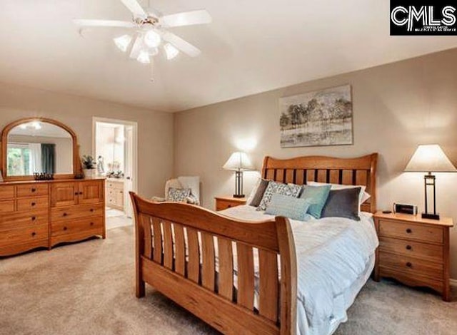 bedroom featuring ceiling fan, light colored carpet, and ensuite bath