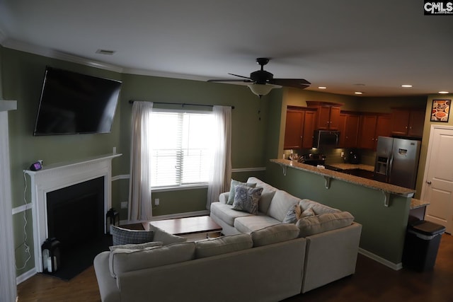 living room with ornamental molding, ceiling fan, and dark hardwood / wood-style floors