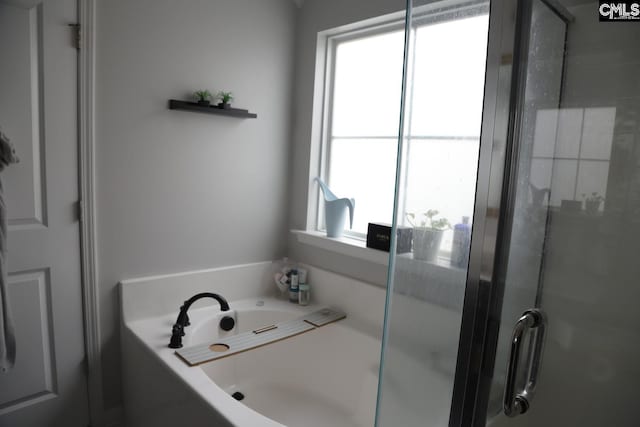 bathroom featuring a wealth of natural light and separate shower and tub