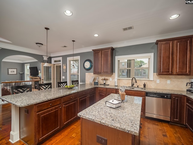 kitchen featuring stainless steel dishwasher, wood-type flooring, decorative light fixtures, and a kitchen island