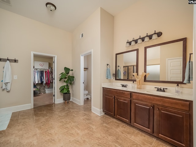 bathroom with high vaulted ceiling, vanity, and toilet