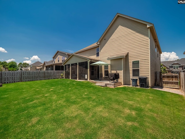 back of house with a sunroom, a yard, and a patio area