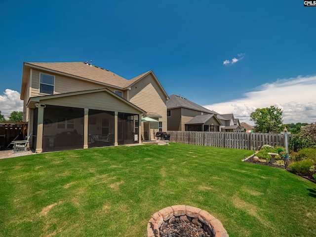 rear view of property featuring a lawn and a sunroom