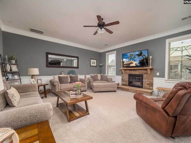 living room with ceiling fan, carpet, ornamental molding, and a fireplace