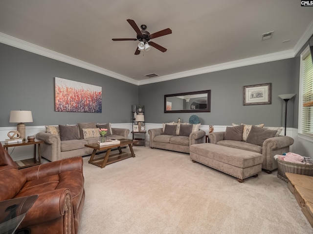 carpeted living room with ornamental molding and ceiling fan