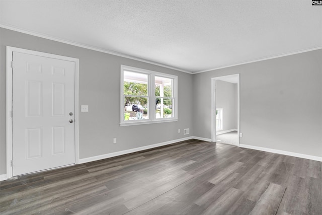 empty room with dark wood-type flooring, a textured ceiling, and ornamental molding