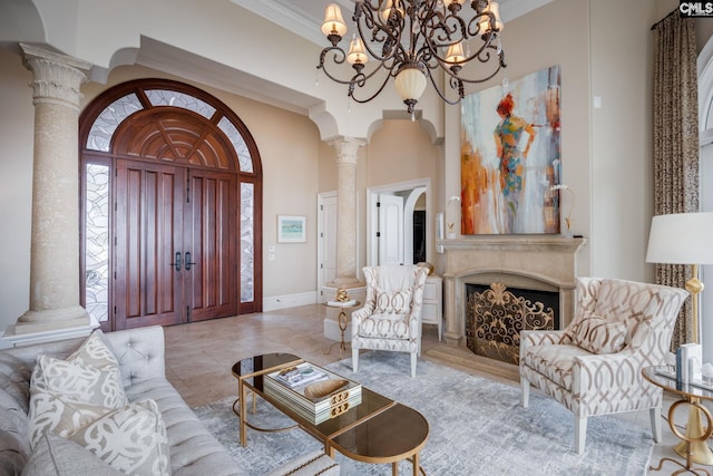 living room featuring ornate columns, a high ceiling, crown molding, and a notable chandelier