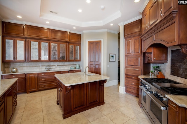 kitchen featuring a center island with sink, a raised ceiling, double oven range, and tasteful backsplash