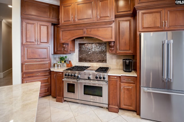 kitchen with light stone countertops, premium appliances, light tile patterned flooring, and tasteful backsplash