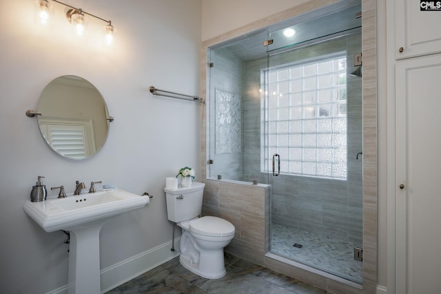 bathroom with a shower with shower door and toilet