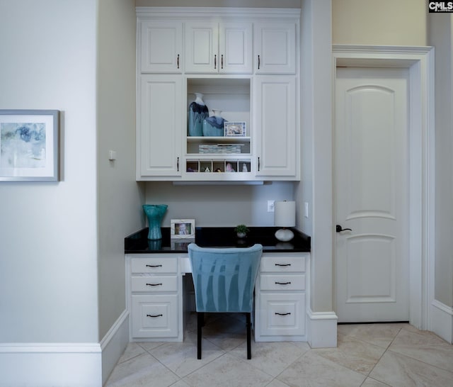 office with built in desk and light tile patterned flooring