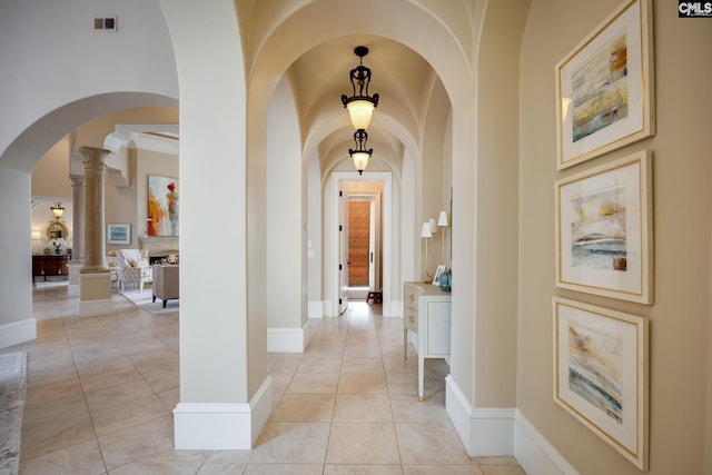 hallway with light tile patterned floors and ornate columns