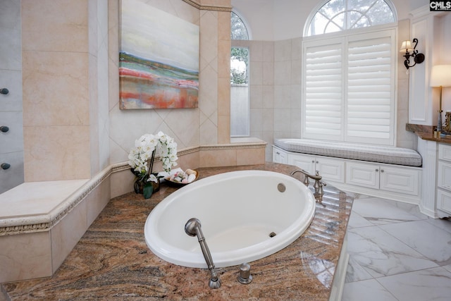 bathroom featuring tile walls and a relaxing tiled tub