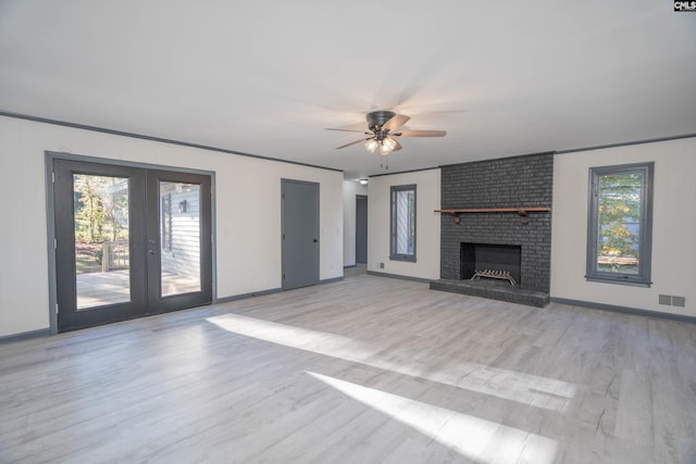 unfurnished living room featuring a fireplace, ceiling fan, light hardwood / wood-style flooring, and french doors