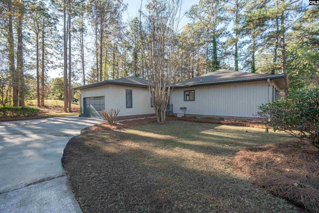 view of side of home featuring a lawn and a garage