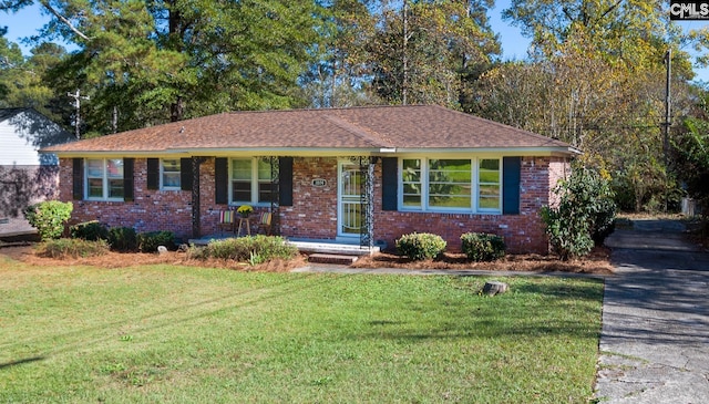 ranch-style house featuring a front lawn and covered porch