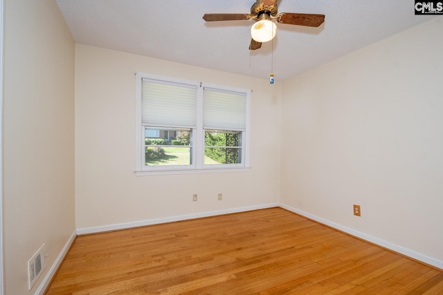 empty room with a textured ceiling, ceiling fan, and light hardwood / wood-style flooring