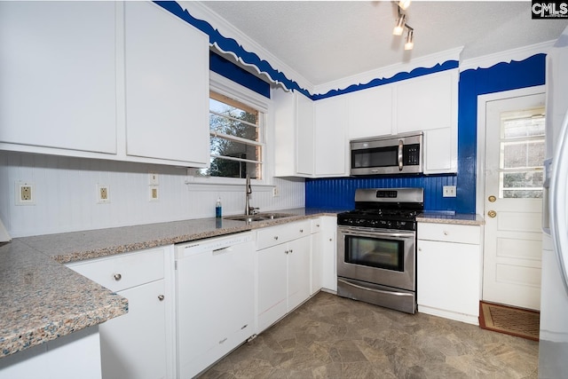 kitchen with stainless steel appliances, white cabinets, sink, and a textured ceiling