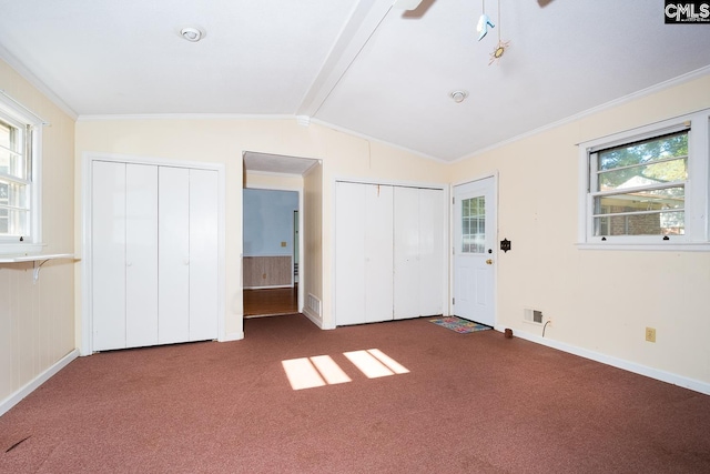 unfurnished bedroom featuring multiple windows, dark carpet, and crown molding