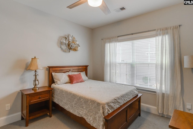 carpeted bedroom with multiple windows and ceiling fan