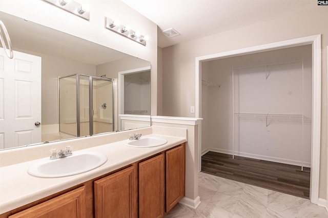 bathroom featuring vanity, an enclosed shower, and wood-type flooring